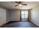Bedroom featuring a ceiling fan, large window, neutral walls, and black floors at 7617 Lakemoor Dr, Riverdale, GA 30296