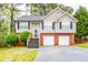 Charming two-story home with gray siding, brick foundation, and a two-car garage at 7617 Lakemoor Dr, Riverdale, GA 30296