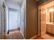 Hallway with wood flooring, leading to a bathroom and multiple doors at 7617 Lakemoor Dr, Riverdale, GA 30296