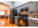 Efficient kitchen layout with gray cabinets, black appliances, and hardwood floors at 7617 Lakemoor Dr, Riverdale, GA 30296