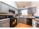 Modern kitchen with gray cabinets, black appliances, and plenty of countertop space at 7617 Lakemoor Dr, Riverdale, GA 30296