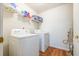 Functional laundry room with a washer, dryer, and shelving unit, maximizing space at 7617 Lakemoor Dr, Riverdale, GA 30296
