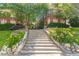 Charming brick building showcasing a long stairwell entrance surrounded by vibrant flowers and lush greenery at 1015 Piedmont Ne Ave # A2, Atlanta, GA 30309