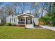 Charming one-story home boasts gray siding, a welcoming front porch, and a well-manicured lawn at 1947 Maywood Nw Pl, Atlanta, GA 30318