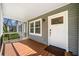 Inviting covered porch with wooden deck flooring and a white front door at 1947 Maywood Nw Pl, Atlanta, GA 30318