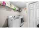 Laundry room with washer, dryer, tile floors and overhead shelving at 1947 Maywood Nw Pl, Atlanta, GA 30318