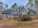 Charming backyard featuring a two-story home, brick foundation, wooden deck, and mature trees at 355 Parker Rd, Covington, GA 30014
