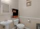 Well-lit half-bathroom with a pedestal sink, toilet, and neutral decor at 355 Parker Rd, Covington, GA 30014