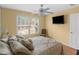 Inviting bedroom with a decorative ceiling fan, wall-mounted TV, and window overlooking a tranquil outdoor view at 355 Parker Rd, Covington, GA 30014