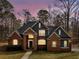 This elegant brick home showcases exterior illumination highlighting architectural details and its well-manicured landscape at 355 Parker Rd, Covington, GA 30014
