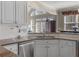 Kitchen featuring stainless steel dishwasher and granite countertops with white cabinets at 355 Parker Rd, Covington, GA 30014
