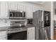 Bright kitchen features stainless steel appliances, white cabinets, and granite countertops at 355 Parker Rd, Covington, GA 30014