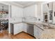 Bright kitchen area with granite countertops, white cabinets, stainless steel appliances, and views into dining area at 355 Parker Rd, Covington, GA 30014