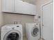 Functional laundry room with a washer, dryer, and white cabinets at 355 Parker Rd, Covington, GA 30014