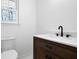 Updated bathroom featuring a dark wood vanity, modern fixtures, and a white toilet at 3569 Vinyard Way, Lawrenceville, GA 30044