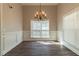 Elegant dining area with chandelier, wainscoting, and hardwood flooring at 405 Rabbits Run, Fayetteville, GA 30214