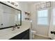 Bright bathroom featuring a large mirror, vanity with a white sink, white tile shower and a window at 7104 Woodland Ln, Alpharetta, GA 30009