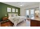 Relaxing bedroom features a calming green accent wall and a private balcony entrance at 7104 Woodland Ln, Alpharetta, GA 30009