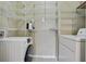 Functional laundry room features modern washer and dryer units and ample shelving space at 7104 Woodland Ln, Alpharetta, GA 30009