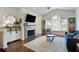 Cozy living room with a fireplace, hardwood floors, large window, and comfortable seating at 7104 Woodland Ln, Alpharetta, GA 30009