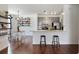 Open concept eat-in kitchen and dining area features stainless appliances, seating, and hardwood floors at 7104 Woodland Ln, Alpharetta, GA 30009