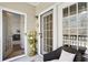 Cozy front porch showing a chair with a white cushion, a plant stand, and an open front door at 7104 Woodland Ln, Alpharetta, GA 30009