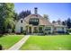 Charming home featuring a covered front porch with verdant landscaping and manicured lawn at 406 Whitmore Nw Dr, Atlanta, GA 30305