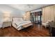 Spacious main bedroom with hardwood floors, luxurious bedding and oversized windows at 406 Whitmore Nw Dr, Atlanta, GA 30305