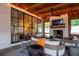 Inviting outdoor patio with a fireplace, TV, stylish furniture, and views through black-framed windows at 406 Whitmore Nw Dr, Atlanta, GA 30305