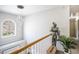 Bright hallway landing featuring a unique chandelier, decorative knight statue, and a view from a large window at 4630 Smokestone Dr, Douglasville, GA 30135