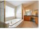 Bright bathroom features a soaking tub, tile flooring, and a double vanity at 1602 Allsworth Se Ct, Smyrna, GA 30082