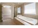 Bathroom featuring a large soaking tub, gold shower trim, and doorway to a bedroom at 1602 Allsworth Se Ct, Smyrna, GA 30082