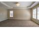 Spacious bedroom featuring a decorative ceiling, plush carpet, and bright window views at 1602 Allsworth Se Ct, Smyrna, GA 30082