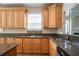 Well-equipped kitchen featuring wood cabinets, granite countertops, and stainless steel sink at 1602 Allsworth Se Ct, Smyrna, GA 30082
