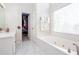 Bright bathroom featuring a walk-in closet and a garden tub under a large window at 4955 Day Lily Nw Way, Acworth, GA 30102