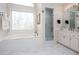 Bright bathroom with a large window over a garden tub and glass-enclosed shower at 4955 Day Lily Nw Way, Acworth, GA 30102