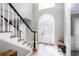 Bright foyer featuring a staircase with black and white banisters and a front door with decorative glass at 4955 Day Lily Nw Way, Acworth, GA 30102