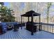 Relaxing outdoor deck with a grill and patio seating surrounded by lush greenery at 4955 Day Lily Nw Way, Acworth, GA 30102