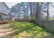 Large grassy backyard featuring a wooden fence and mature trees, offering privacy at 971 Lake Watch Ct, Stone Mountain, GA 30088