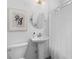 Bright bathroom features a pedestal sink, stylish light fixture, and framed botanical print at 1479 Hartford Sw Ave, Atlanta, GA 30310