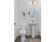 Cozy bathroom showcases a pedestal sink, updated fixtures, and a decorative mirror and print at 1479 Hartford Sw Ave, Atlanta, GA 30310