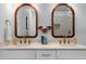 Bathroom featuring double vanity, quartz countertops, framed mirrors, gold fixtures, and patterned shower tile at 1479 Hartford Sw Ave, Atlanta, GA 30310