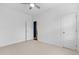 Bright bedroom featuring neutral carpet, ceiling fan and white trim, with a glimpse into another room at 1479 Hartford Sw Ave, Atlanta, GA 30310