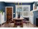 Cozy dining room featuring a wooden table, red upholstered chairs, modern lighting, and hardwood floors at 1479 Hartford Sw Ave, Atlanta, GA 30310