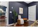 Inviting entryway with dark blue walls, brown leather bench, houseplant, and view into the dining room at 1479 Hartford Sw Ave, Atlanta, GA 30310