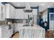 Bright kitchen with white cabinets, marble countertops, stainless steel appliances, and modern fixtures at 1479 Hartford Sw Ave, Atlanta, GA 30310