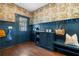 Stylized mud room with blue wainscoting, built-in shelves and racks, and designer wallpaper at 1479 Hartford Sw Ave, Atlanta, GA 30310