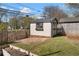 Well-maintained storage shed with a gated yard and adjacent garden beds in a green yard at 1479 Hartford Sw Ave, Atlanta, GA 30310