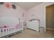 A cozy bedroom featuring a white crib, dresser, and tasteful decorations at 114 Connie Dr, Dallas, GA 30157