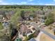 Aerial view showing the roof, back patio, pool and surrounding neighborhood and wooded area at 303 Rolling Rock Se Rd, Marietta, GA 30067